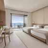 Habitacion de hotel con camas dobles, gran ventanal, colores marron y beig